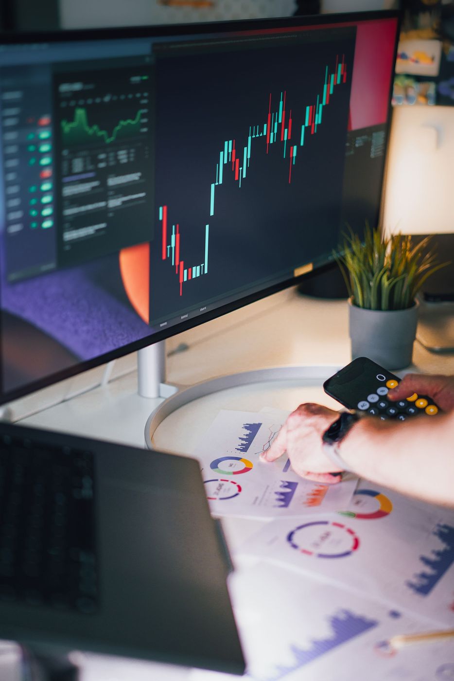 Market analyst reviewing charts and reports at a desk